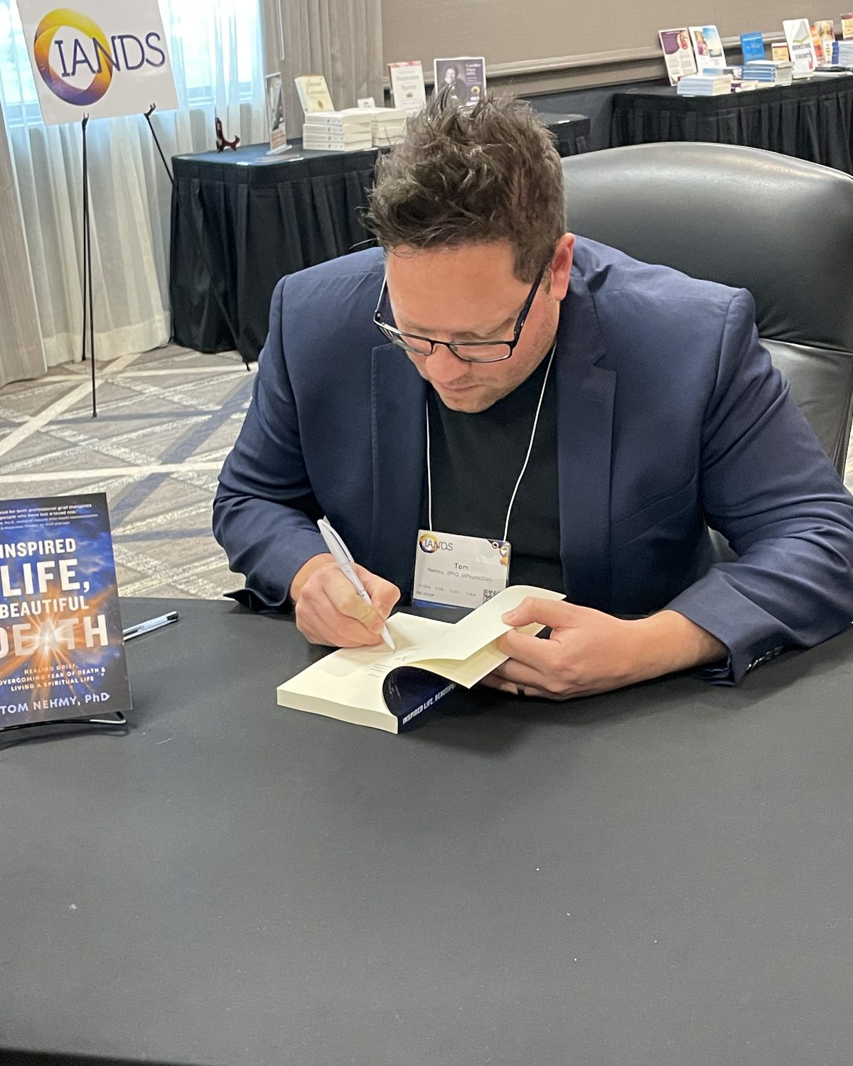 Tom Nehmy signing copies of Inspired Life, Beautiful Death at the IANDS 2025 conference